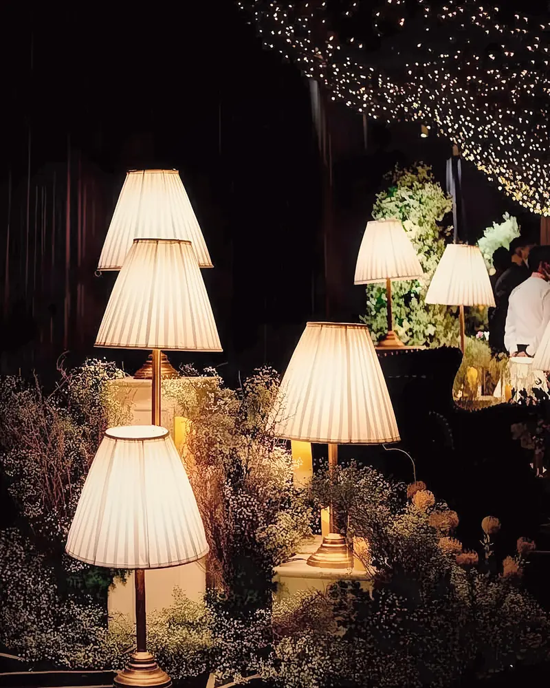 Warm pleated lamps glowing in a garden reception after dark